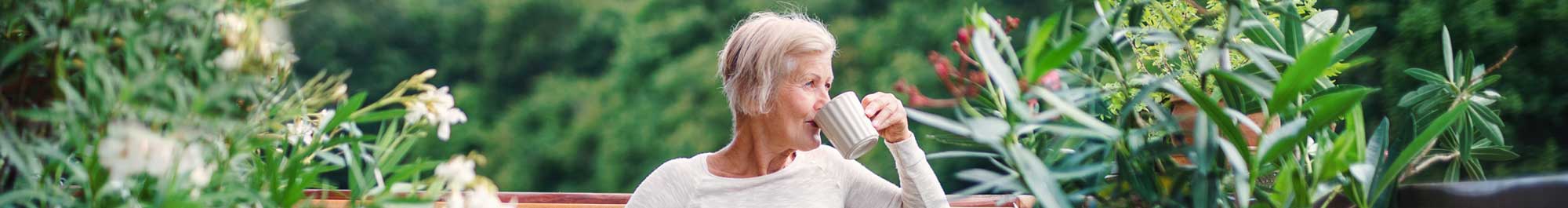 woman serenely drinking coffee on her patio